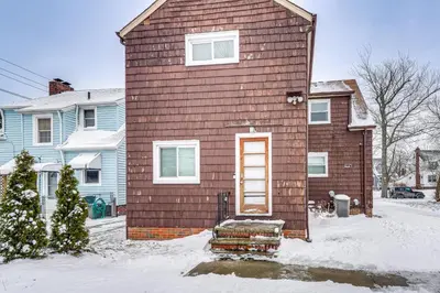 a house with a door in the snow at Bring the Family! Mid-Century Modern Gem in Euclid in Euclid
