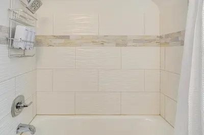 a bathroom with a bath tub with a shower curtain at Bring the Family! Mid-Century Modern Gem in Euclid in Euclid