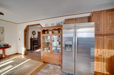a kitchen with a refrigerator and wooden cabinets at 5-Acre Hocking Hills Hideaway! Pet-Friendly Home in New Plymouth