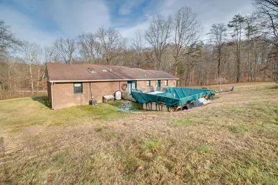 a house with a tarp on it in a field at 5-Acre Hocking Hills Hideaway! Pet-Friendly Home in New Plymouth