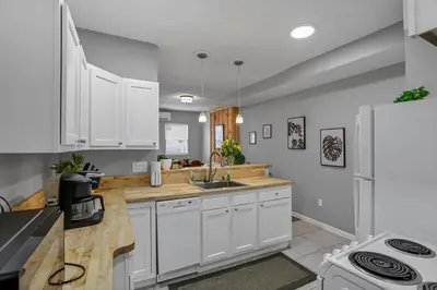 a kitchen with white cabinets and a white refrigerator at Modern Columbus 2BR Near COSI & Arena District in Columbus