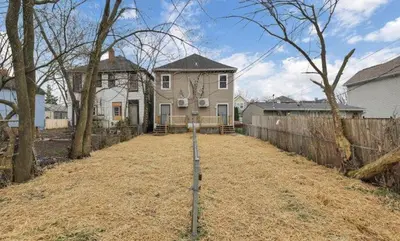 a house in a yard with a fence at Modern Columbus 2BR Near COSI & Arena District in Columbus