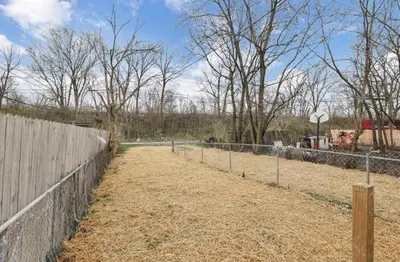 a fenced in pasture with a fence and trees at Modern Columbus 2BR Near COSI & Arena District in Columbus