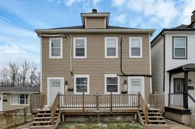 a house with a wooden deck in front of it at Modern Columbus 2BR Near COSI & Arena District in Columbus