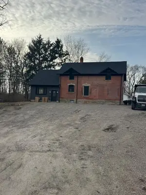a large brick house with a car parked in front of it at New Group Space - Sleeps 20! Near Sports Center in Huron