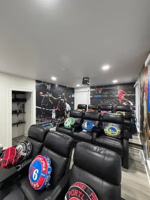 a gym with black leather couches and helmets on the wall at New Group Space - Sleeps 20! Near Sports Center in Huron