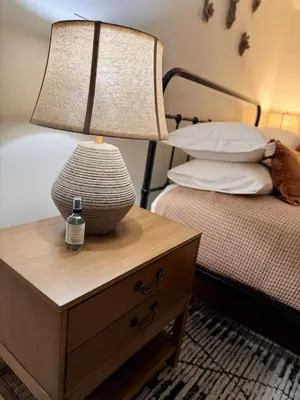 a lamp on a night stand next to a bed at Logan’s Lookout over Mohican - Modern Farmhouse in Loudonville