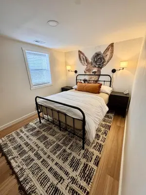 a bedroom with a bed with a rabbit head on the wall at Logan’s Lookout over Mohican - Modern Farmhouse in Loudonville
