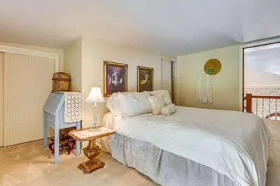 a bedroom with a bed and a table with a lamp at Dalton Retreat w Deck, Fire Pit and 6 Smart TVs in Dalton