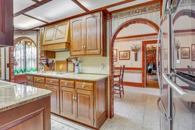 a kitchen with wooden cabinets and an archway at Dalton Retreat w Deck, Fire Pit and 6 Smart TVs in Dalton