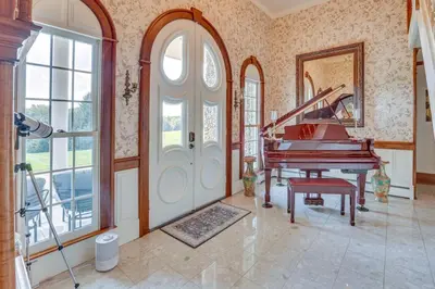 a living room with a piano and a staircase at Dalton Retreat w Deck, Fire Pit and 6 Smart TVs in Dalton