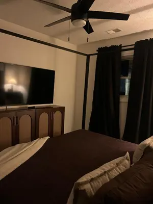 a bedroom with a bed and a flat screen tv at King suite and Hot Tub near the Greene in Dayton