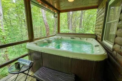 a jacuzzi tub in a cabin in the woods at Havenwood in Logan