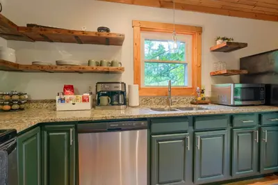 a kitchen with green cabinets and a sink at Havenwood in Logan