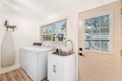 a kitchen with a sink and a washing machine at The Sleepy Tiki - game room, tiki lounge, firepit in Mason