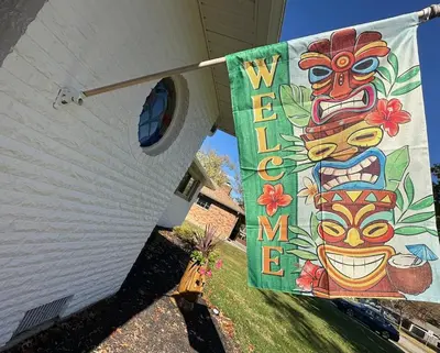 a banner hanging on the side of a house at The Sleepy Tiki - game room, tiki lounge, firepit in Mason