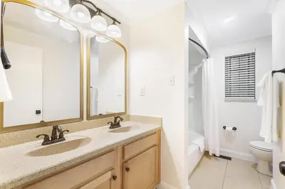 a bathroom with two sinks and a toilet at The Sleepy Tiki - game room, tiki lounge, firepit in Mason