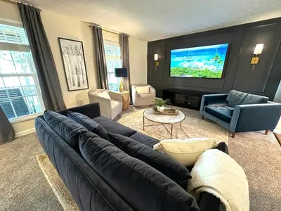 a living room with a large couch and a flat screen tv at Mason Ohio Home large private yard firepit game room in Mason