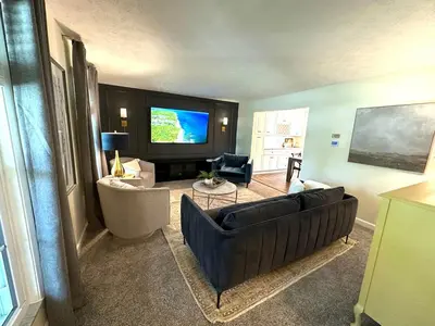 a living room with a couch and a flat screen tv at Mason Ohio Home large private yard firepit game room in Mason