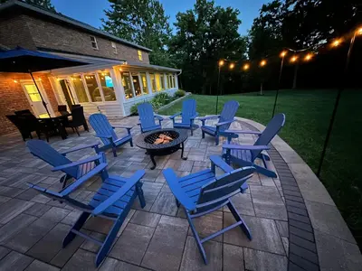 a patio with blue chairs and a fire pit at Mason Ohio Home large private yard firepit game room in Mason