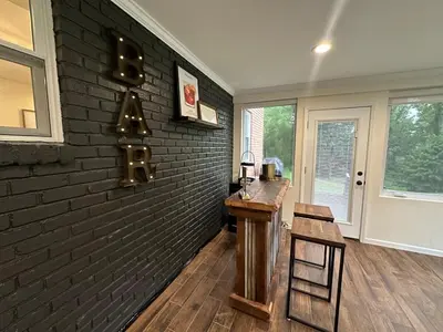 a room with a brick wall with a table and chairs at Mason Ohio Home large private yard firepit game room in Mason
