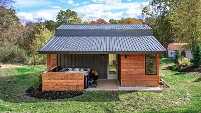 a small cabin with a metal roof on the grass at Modern Cabin next to Salt Fork State Park