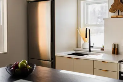 a kitchen with a refrigerator and a bowl of fruit on a table at Modern Cabin next to Salt Fork State Park