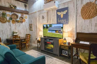 a living room with a tv and a blue couch at Hot Tub & Firepit Your Winter Blues Retreat in Amherst