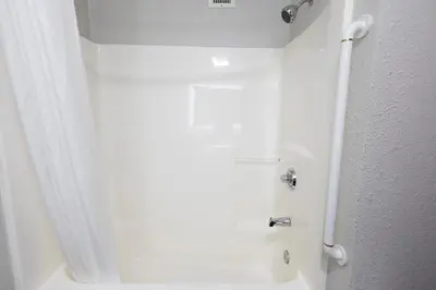 a bathroom with a shower with a white shower curtain at Countryside Inn and Suites in Mount Orab