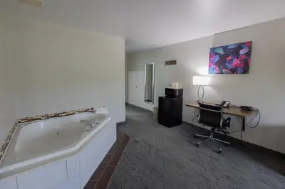 a bathroom with a tub and a desk and a computer at Countryside Inn and Suites in Mount Orab