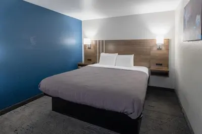 a large bed in a room with a blue wall at Countryside Inn and Suites in Mount Orab