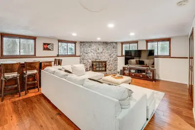 a living room with a white couch and a kitchen at Close to Hospitals and Downtown Cleveland Home in North Olmsted