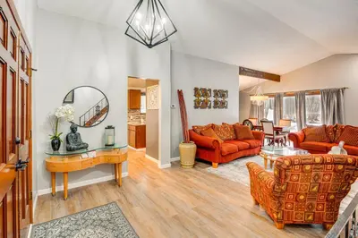 a living room with orange couches and a table at Close to Hospitals and Downtown Cleveland Home in North Olmsted