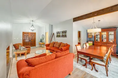 a living room with orange furniture and a wooden table at Close to Hospitals and Downtown Cleveland Home in North Olmsted