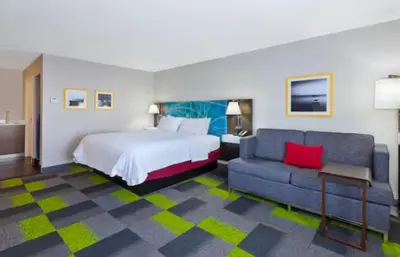 a hotel room with a bed and a couch at Hampton Inn in Marysville