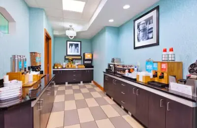 a restaurant with blue walls and counters in a store at Hampton Inn in Marysville