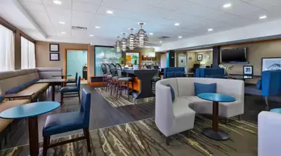 a lobby with chairs and tables and a bar at Hampton Inn in Marysville