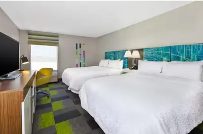 a hotel room with two beds and a flat screen tv at Hampton Inn in Marysville