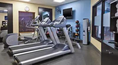 a gym with treadmills and ellipticals in a room at Hampton Inn in Marysville