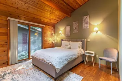 a bedroom with a bed and a chair and a window at Nature Spa House | •Pool •Hot Tub •Sauna •Pvt Lake in New Richmond