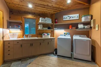 a kitchen with a sink and a washer and dryer at Nature Spa House | •Pool •Hot Tub •Sauna •Pvt Lake in New Richmond