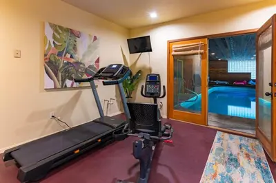 a room with a gym with a treadmill and a swimming pool at Nature Spa House | •Pool •Hot Tub •Sauna •Pvt Lake in New Richmond