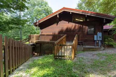 a house with a wooden fence and a wooden deck at Nature Spa House | •Pool •Hot Tub •Sauna •Pvt Lake in New Richmond
