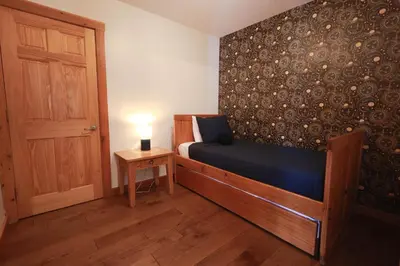 a bedroom with a bed and a table with a lamp at Golden goat cabin in Logan