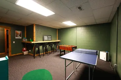 a classroom with tables and a ping pong table at Golden goat cabin in Logan