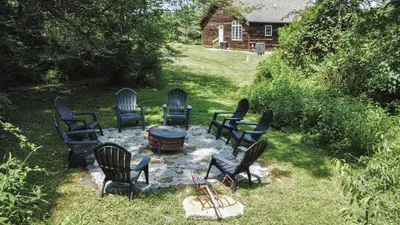 a group of chairs sitting around a table in a yard at Golden goat cabin in Logan