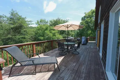 a patio with a table and an umbrella on a deck at Golden goat cabin in Logan