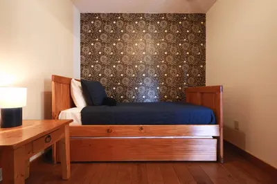 a bedroom with a bed and a table and a wall at Golden goat cabin in Logan