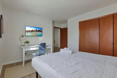 a bedroom with a white bed and a desk at Modern Retreat with Forest Views 3BR Near Airport & Downtown in Gahanna