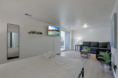 a white bedroom with a bed and a couch at Modern Retreat with Forest Views 3BR Near Airport & Downtown in Gahanna